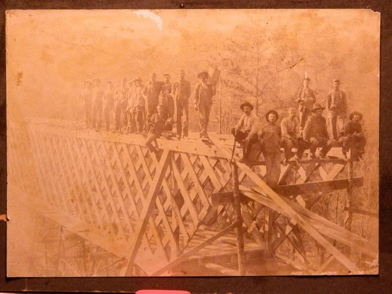 Construction crew standing on the exposed Town Lattice truss of the <a href=