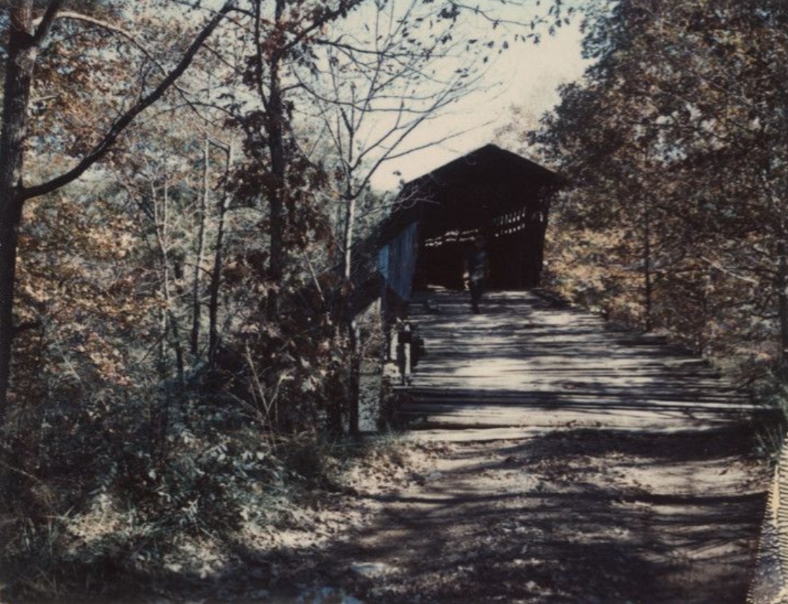 A figure walking through the covered Standridge Bridge in afternoon light, October 25, 1967