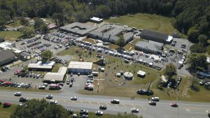 Aerial view of a Hayden Day crowd, vendor tents, rides, and classic cars around the Hayden town hall park